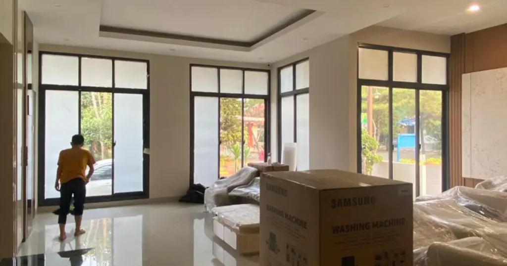 Proses pemasangan smart film pada jendela rumah minimalis.