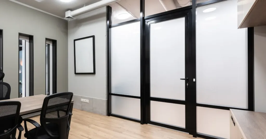 Gambar smart glass yang digunakan di ruang tamu modern dengan tampilan transparan dan buram.